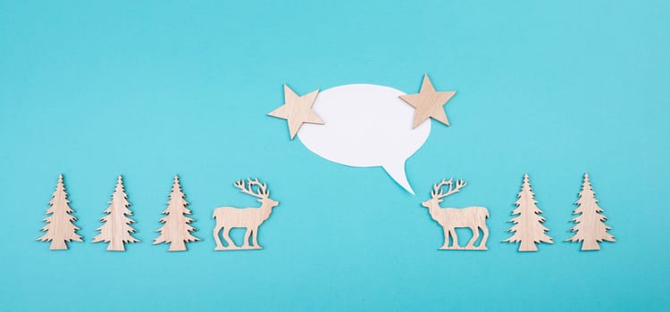 Two cute reindeers talking to each other, speech bubble with copy space, christmas greetings, blue colored background