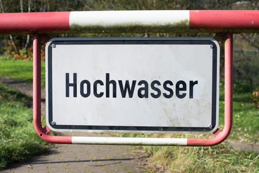 High water sign in german language, next to the river Moselle in Trier, warning for flood, climate change, enviromental issue