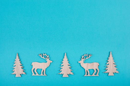 Reindeers, christmas trees, blue colored background, copy space for text, greeting card, winter backdrop