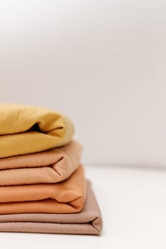 Stacks colorful cotton fabric, clothes. Copyspace