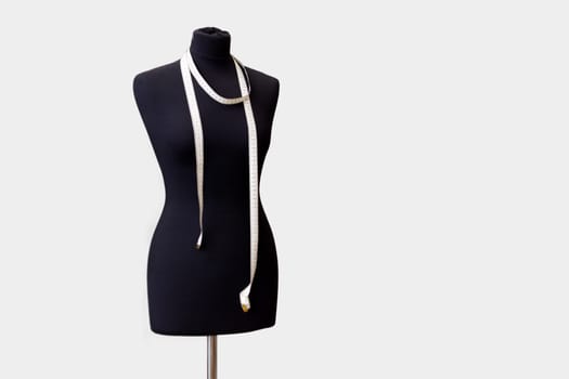 black tailor mannequin for sewing clothes with a measuring tape. full-length mannequin isolated on white