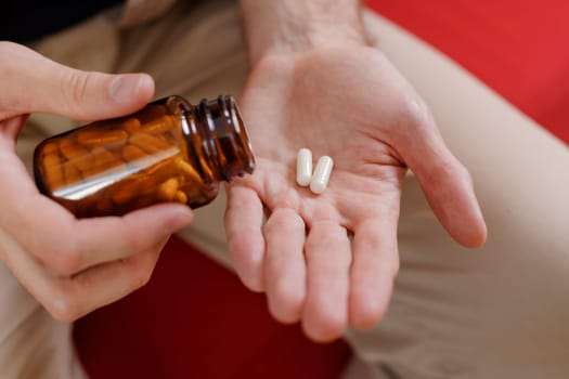 Close up of man hands taking medical supplements.