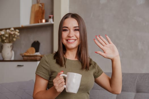 Head shot close up portrait happy pleasant young woman looking at camera, waving hello. Pretty millennial lady communicating with parents via video call. Attractive female blogger greeting followers.