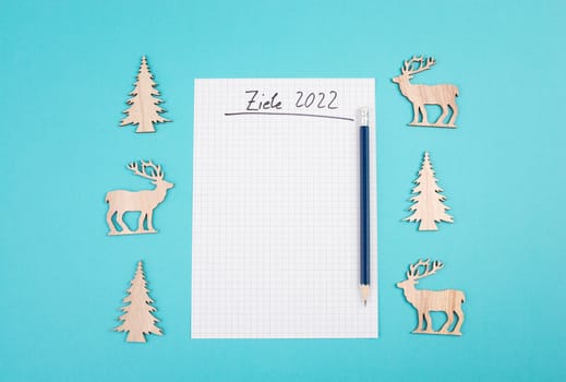 Goals 2022, empty paper, christmas time, making plans for the new year, copy space, blue colored background, german language