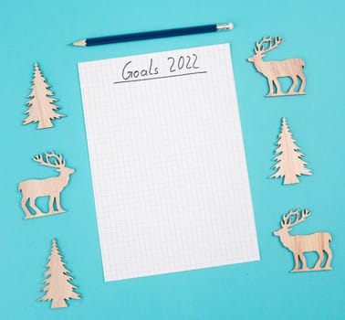 Goals 2022, empty paper, christmas time, making plans for the new year, copy space, blue colored background
