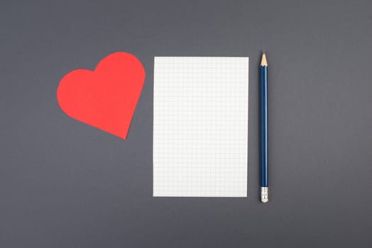 Empty paper with a pen on a dark grey background, red heart on the side, copy space for text, emotion,business concept, education, minimalism