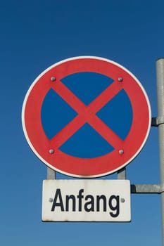 street sign beginning of no stopping under blue sky