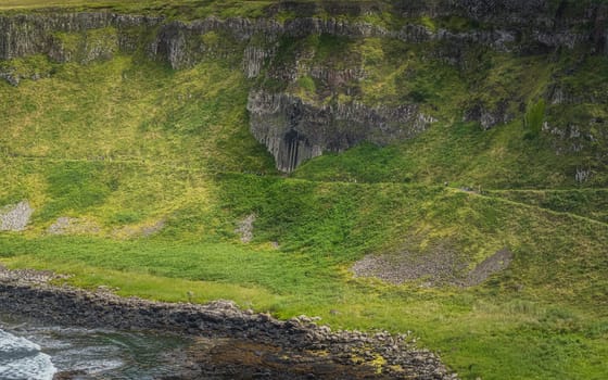 Tourists admiring The Amphitheatre in Giants Causeway, seen from top of the cliff, Wild Atlantic Way and UNESCO world heritage, Northern Ireland