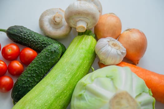 Vegetables and porcini mushrooms lie on a white background. High quality photo