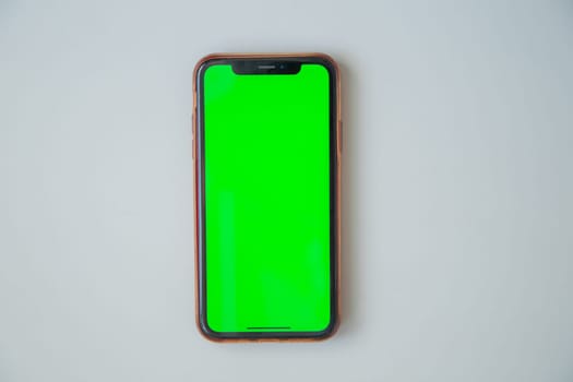The phone with a green screen is on a white background. High quality photo