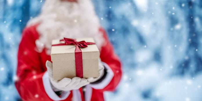 Santa Claus holding in his hands present box. Concept of celebration and holidays.