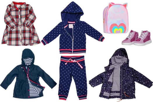 Collage set of little girl autumn clothing isolated on a white background. The collection of two rain jackets, a dress, a hoody and sweat pants, shoes and a bag. Kids winter fashion.