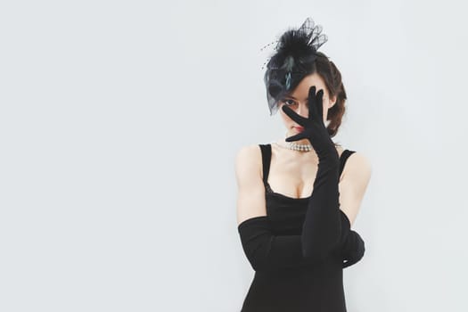Beautiful brunette woman in black dress and gloves
