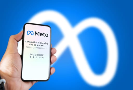 Menlo Park, CA, USA, October 28 2021: hand holding a phone with the Meta mobile app on the screen and the logo blurred in the background. Meta is a technology company that will replace Facebook Inc.
