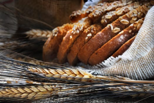 Bread and wheat ears on vintage wooden board