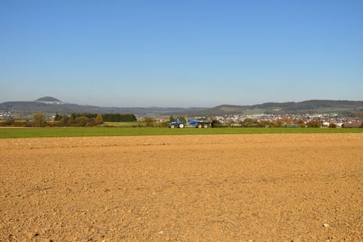 tractor throwing cow manure in a meadow in Germany