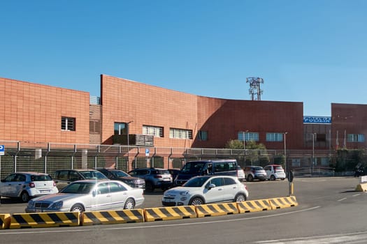 Civitavecchia. Italia - December 19, 2024: The police station in Civitavecchia, Italy, featuring a large parking lot with multiple cars under a clear blue sky. Concept: Urban law enforcement facility.