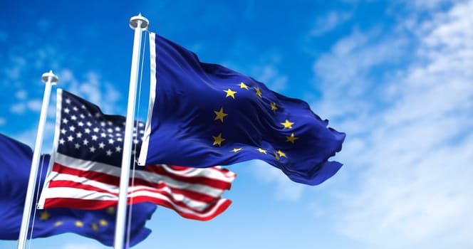 The flags of the European Union and the United States of America waving in the wind. International relations and diplomacy.
