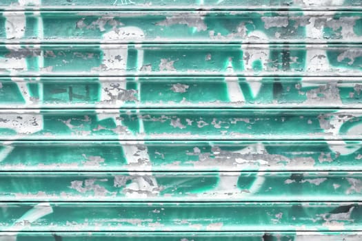 Turquoise metal shutter with peeling paint. Ideal use for background / wallpaper.