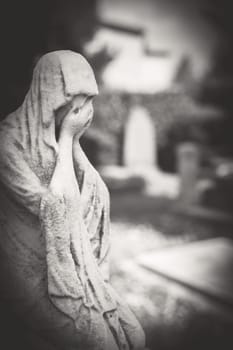 Suffering young woman. Statue of a desperate woman. Defocused blurry background. Retro style photo.