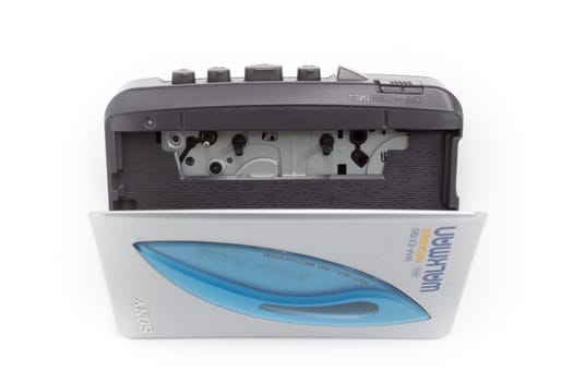 Sony Walkman. Vintage portable audio tape compact cassette player with headphones and cassette. Device on white background. Bergamo, ITALY - March 24, 2021.