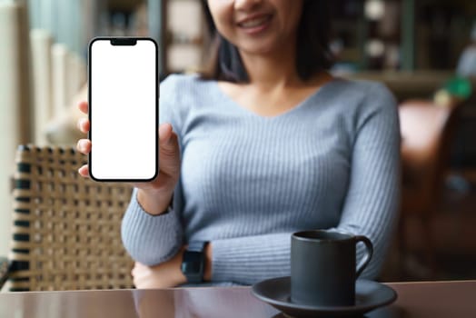 women sit back and relax in the hotel restaurant, feeling happy showing phone white blank screen