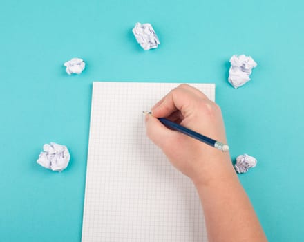 Empty notebook with paper crumbles around, blue colored background, copy space, new idea, brainstorming