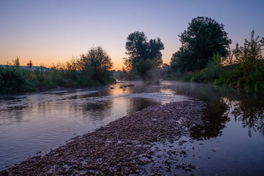 Morning dawn at german river rems with pebbles scene