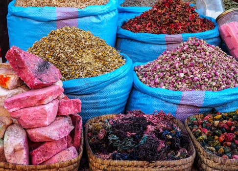 Piles of dried rose and other flowers used as natural fragrances displayed on souk - traditional street market in Morocco.
