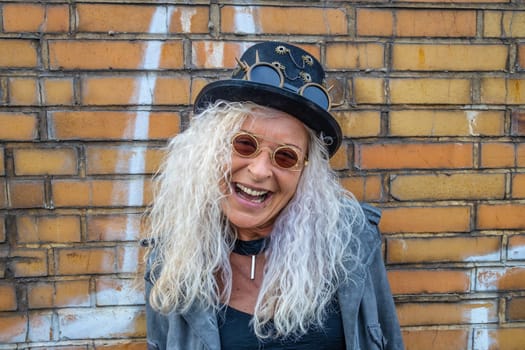 Laughing Steam Punk Lady standing on a Brick Wall Background