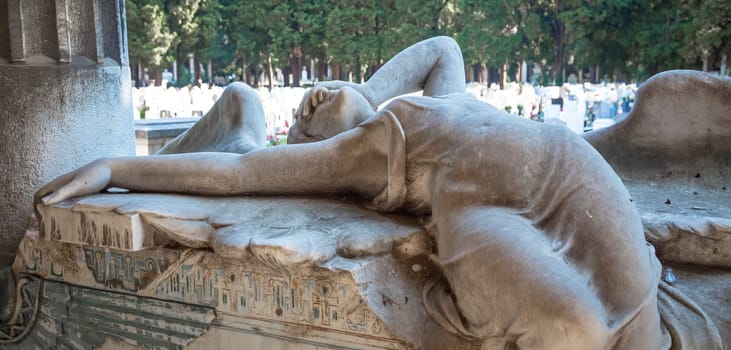 GENOA, ITALY - June 2020: antique statue of angel (1910, marble) in a Christian Catholic cemetery - Italy