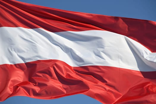 The red,white,red Austrian national flag waves in the wind.