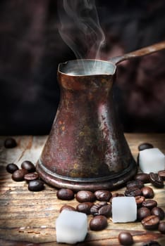 Old-fashioned oriental coffee pot on grunge wooden plank