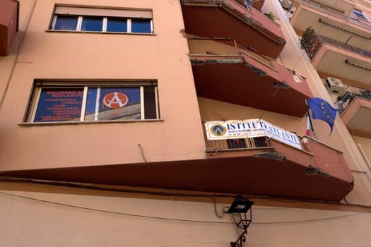 Civitavecchia, Italy - December 19, 2024: Educational institute showing the courses offered. Above, a balcony with a banner and flags of Italy and the European Union. Concept: Education and training.