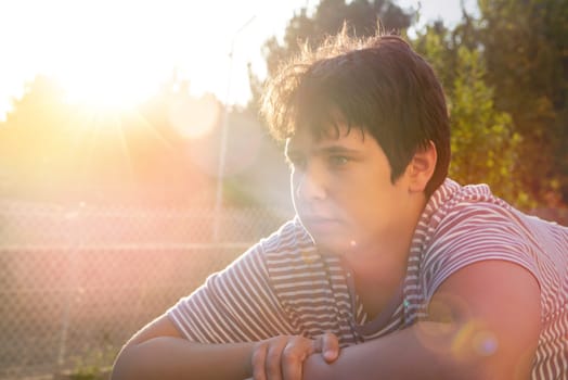 Happy handsome boy posing outdoors at sunset