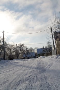 Road in the snow in the rural village in Belarus. Vertical image