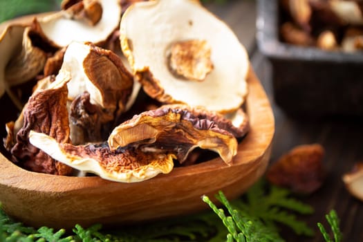 dried mushrooms boletus sliced, on a plate, on an old wooden dark background closeup