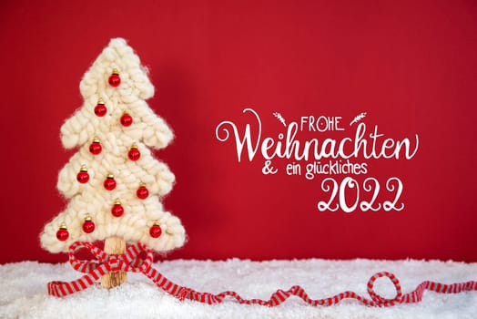 German Calligraphy Frohe Weihnachten Und Ein Glueckliches 2022 Means Merry Christmas And A Happy 2022. White Fabric Christmas Tree With Snow And Red Background. Decoration Like Red Ribbon