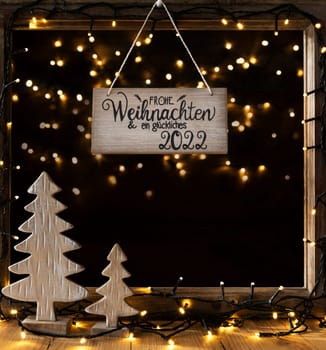 Window With Sign With German Calligraphy Frohe Weihnachten Und Ein Glueckliches 2022 Means Merry Christmas And A Happy 2022. Night With Fairy Lights And Christmas Decoration Like Tree