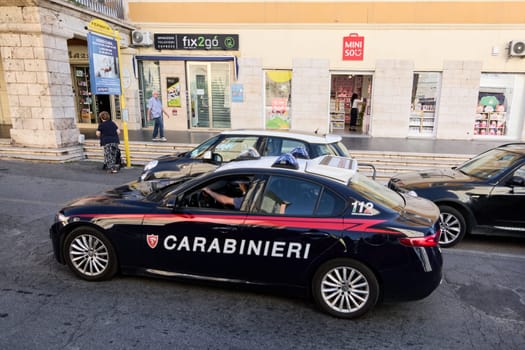 Civitavecchia. Italia - December 24, 2024: An Italian Carabinieri police car patrols a street in Civitavecchia, Italy, in front of local shops, highlighting public safety and urban life.