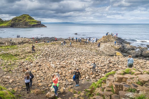 Bushmills, Northern Ireland, Aug 2019 Tourists photographing hexagonal rock formation in Giants Causeway, Wild Atlantic Way and UNESCO world heritage