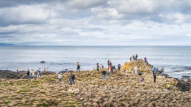 Bushmills, Northern Ireland, Aug 2019 Tourists sightseeing hexagonal rock formation in Giants Causeway, Wild Atlantic Way and UNESCO world heritage