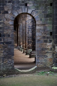 A doorway leading to gothic cloisters dark moody scene