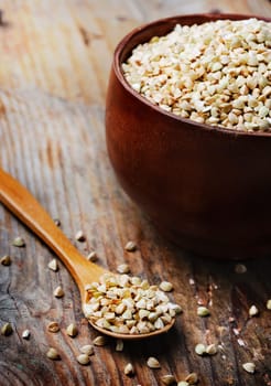 Buckwheat in bowl on wooden background
