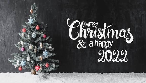English Calligraphy Merry Christmas And A Happy 2022. Tree With Colorful Ball Ornament And Snow