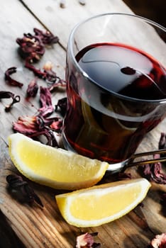 Cup of tea with dried hibiscus and lemon slices