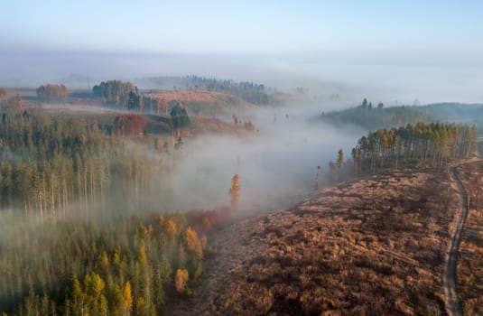 Aerial view of autumn sunrise countryside, traditional fall landscape with rising sun in Central europe. Foggy and misty sunrise. Frozen landscape from bird eye. Czech Republic,Vysocina highland