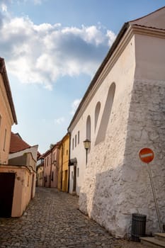 Narrow picturesque street with colorful buildings in historic center in medieval city Trebic, aisle in renaissance and baroque historical buildings at jewish quarter. Czech Republic
