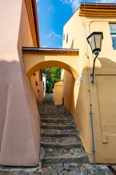 Narrow picturesque street with colorful buildings in historic center in medieval city Trebic, aisle in renaissance and baroque historical buildings at jewish quarter. Czech Republic