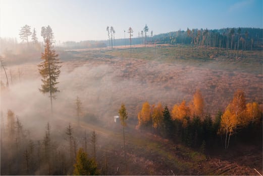 Aerial view of autumn sunrise countryside, traditional fall landscape with rising sun in Central europe. Foggy and misty sunrise. Frozen landscape from bird eye. Czech Republic,Vysocina highland